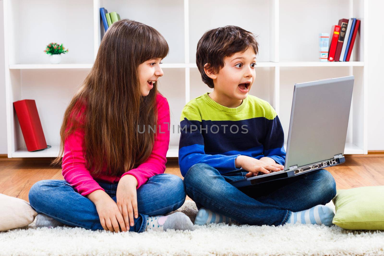 Image of happy children using laptop.