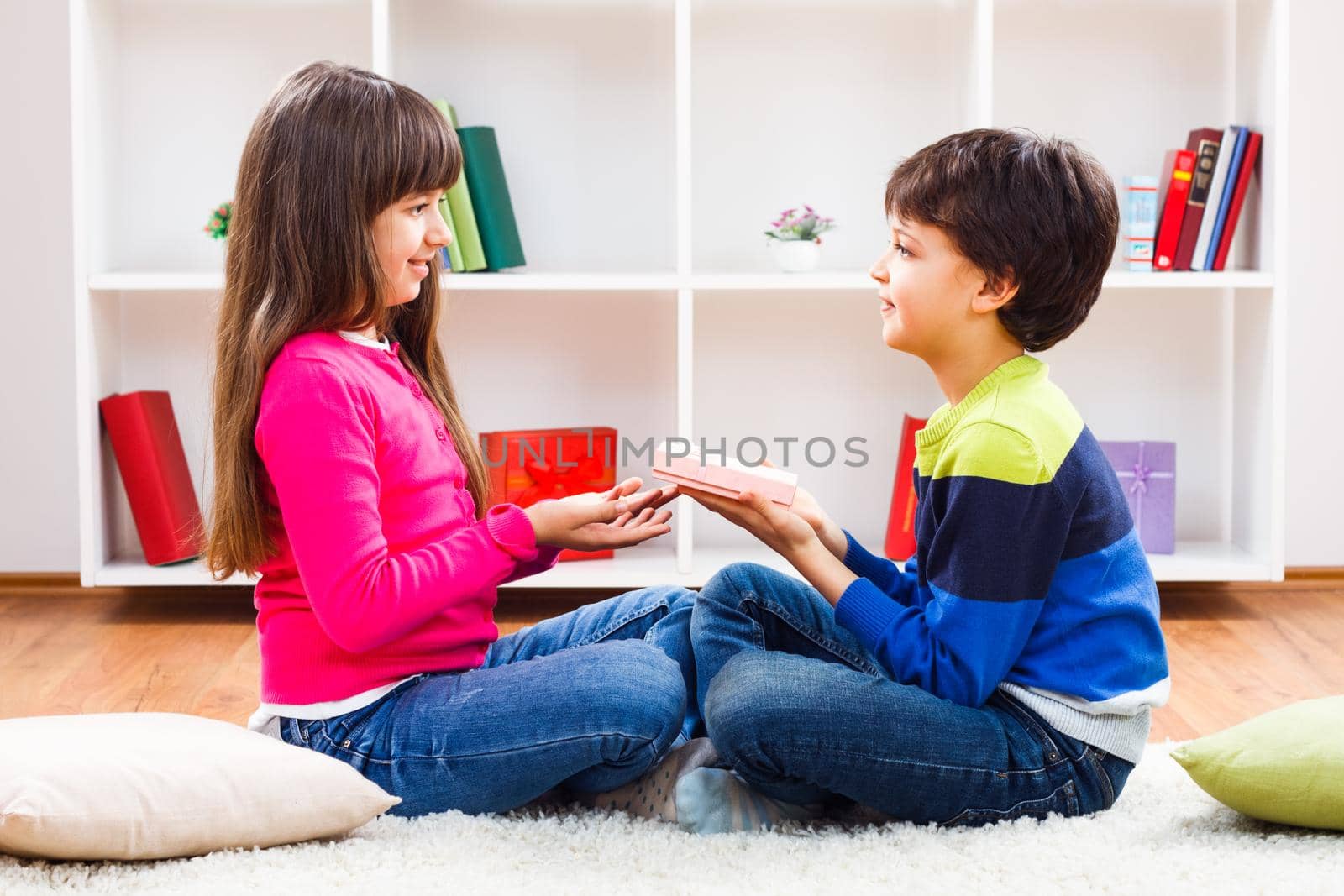 Image of little boy  giving a gift to a little girl.