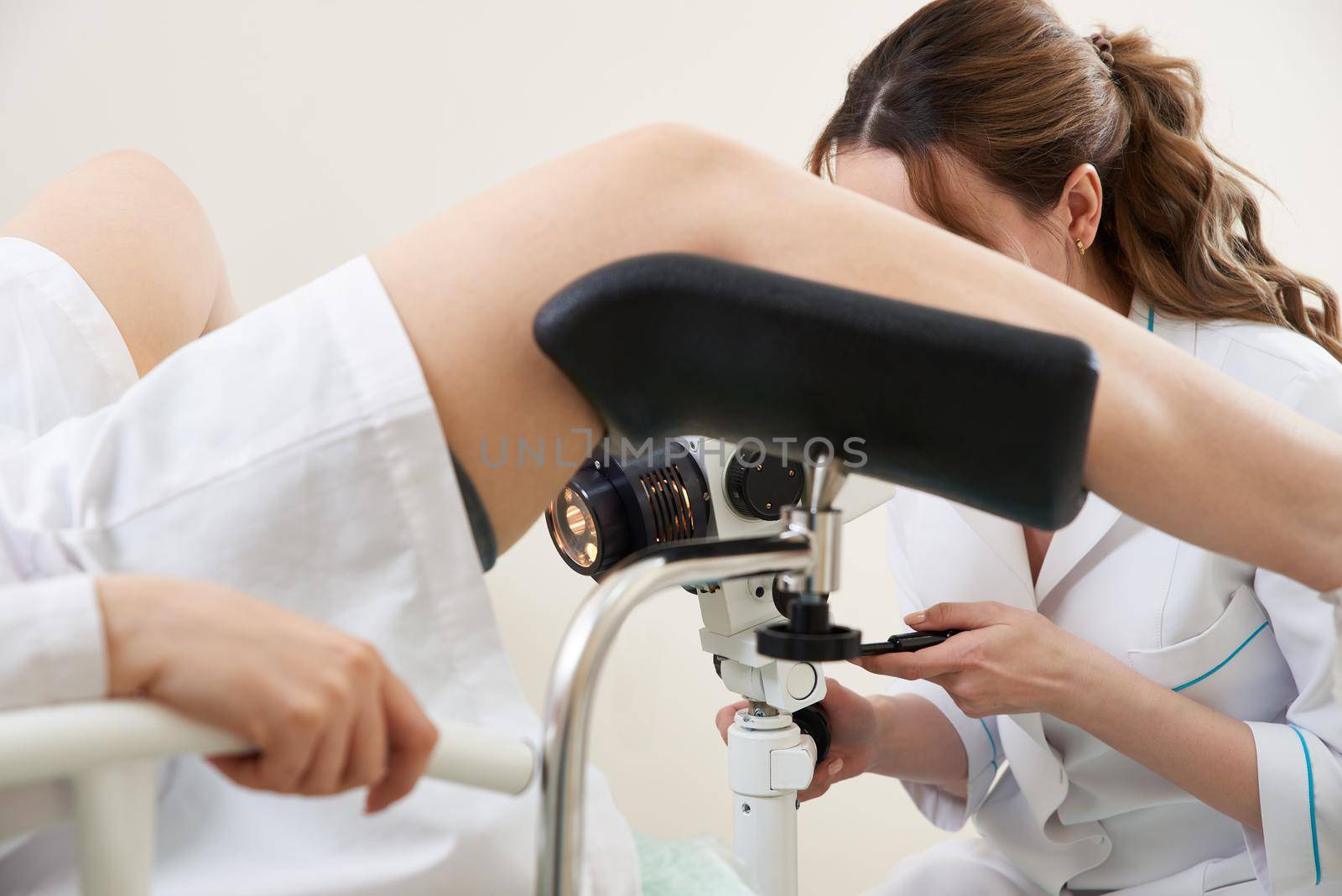 woman gynecologist working with colposcope and makes microscopic investigation in clinic
