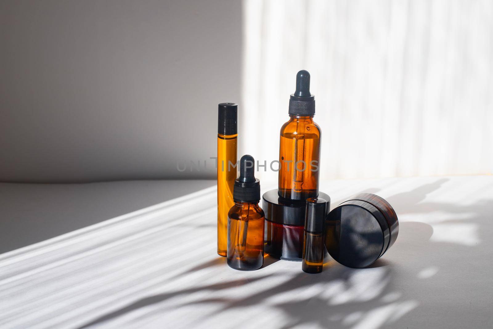 Cosmetic jars with oils on a white background . Light and shadows. Minimalism. Copy space. Cosmetology. Skin care. Cosmetic bottles. spa treatments
