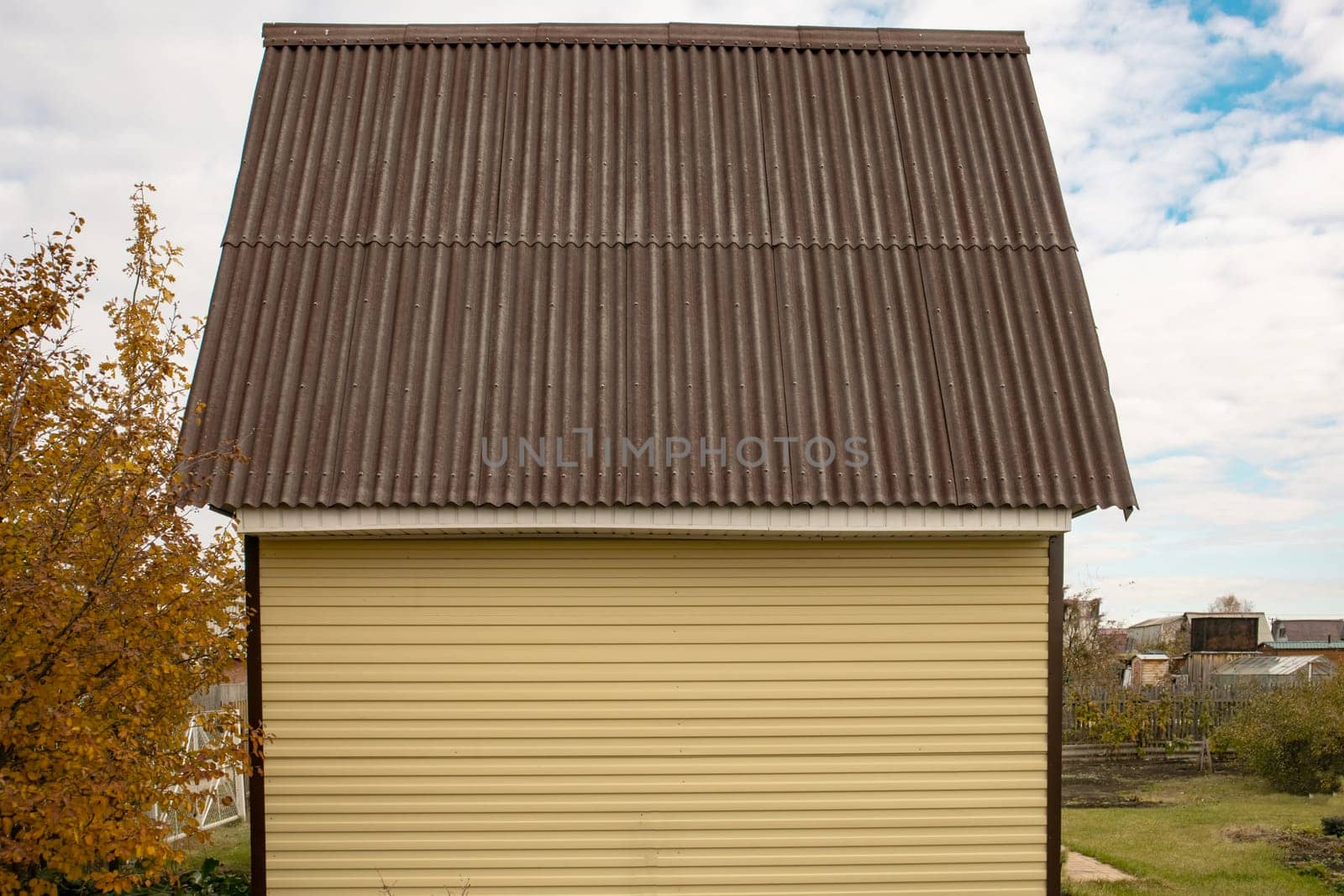 New country house with yellow siding and brown roof.