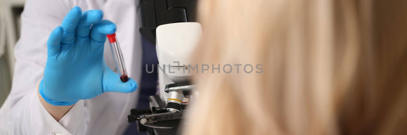 Laboratory assistant prepares blood for analysis for antibodies and viruses. Patient taking blood test in clinic