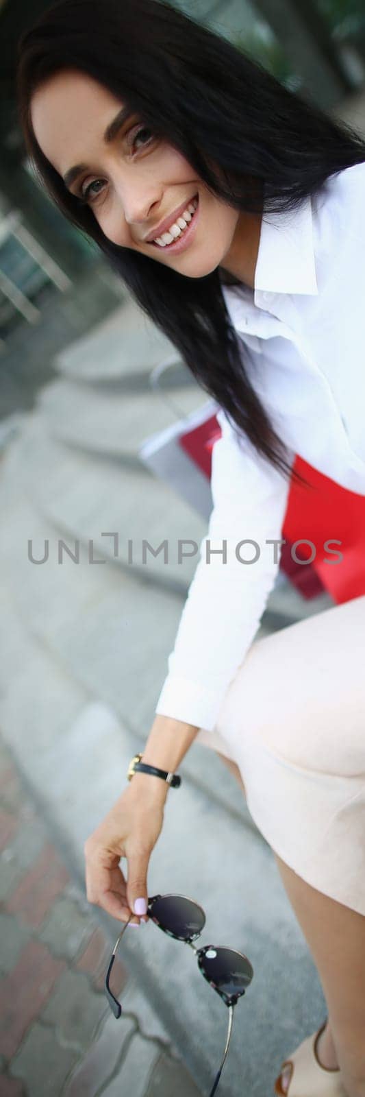 Smiling happy woman with packages after shopping. Emotions of new purchases and shopping