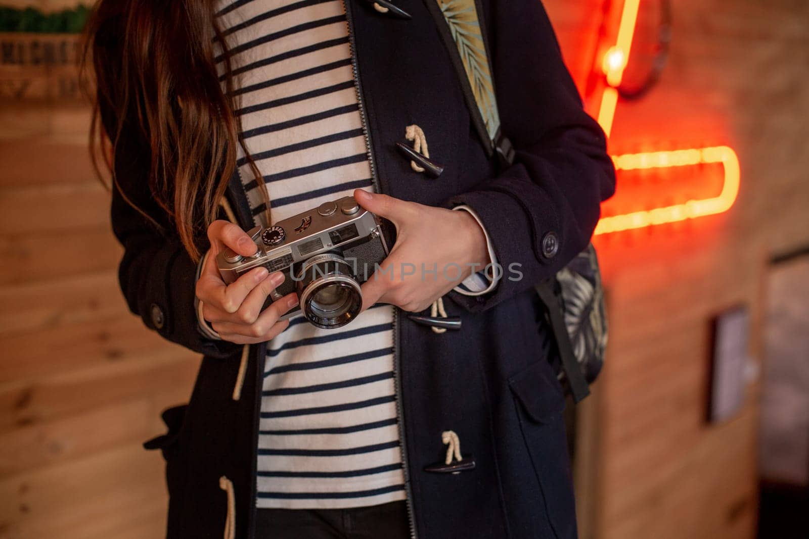 Happy young hipster woman holds retro photo camera. Having fun in the city with camera, travel photo of photographer.