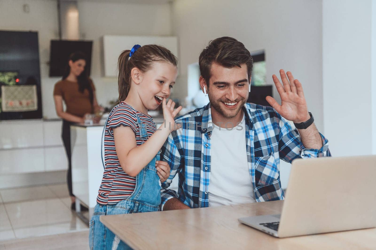 Father and daughter in the modern house talking together on a laptop with their family during holidays. The life of a modern family.