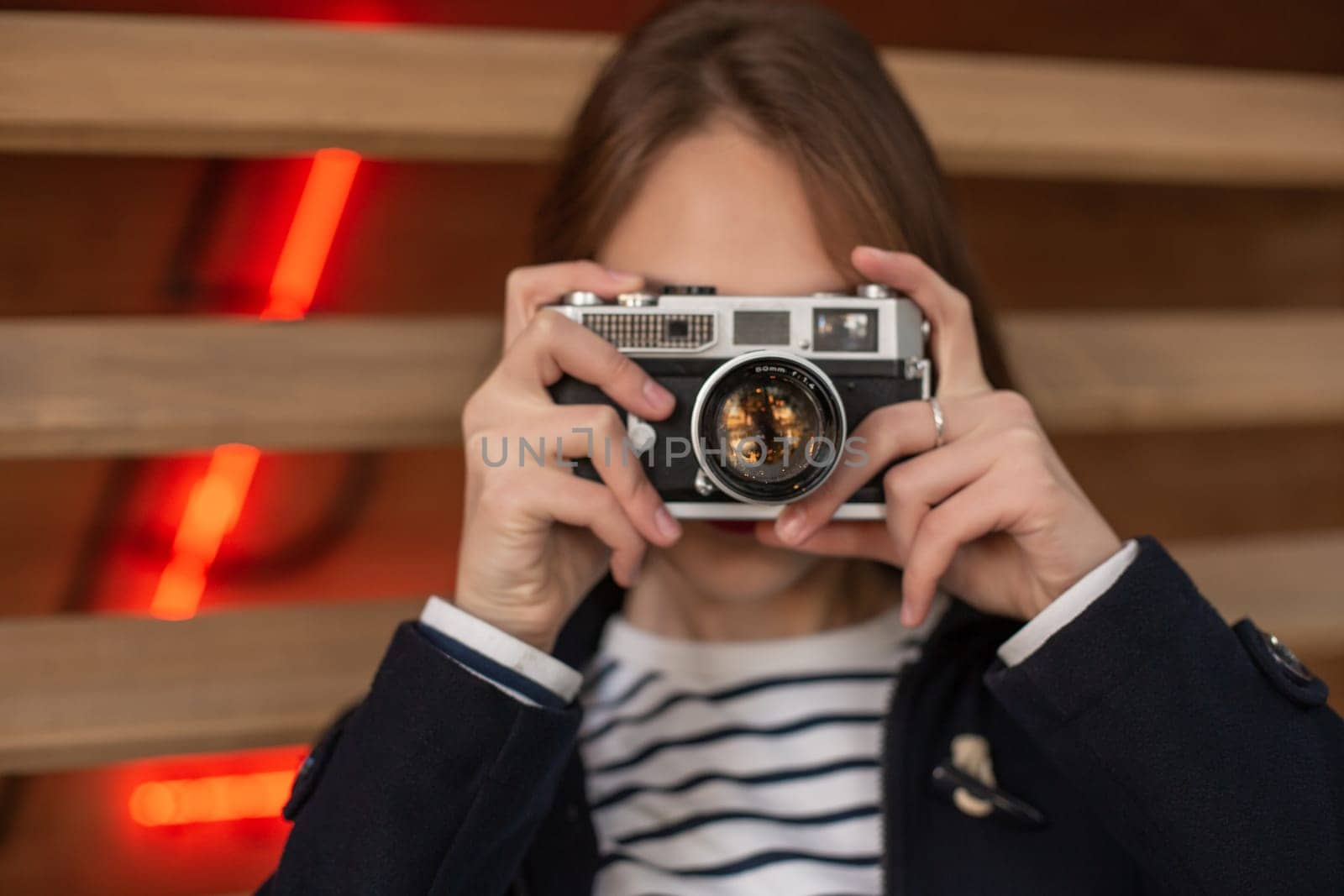 Happy young hipster woman holds retro photo camera. Having fun in the city with camera, travel photo of photographer.