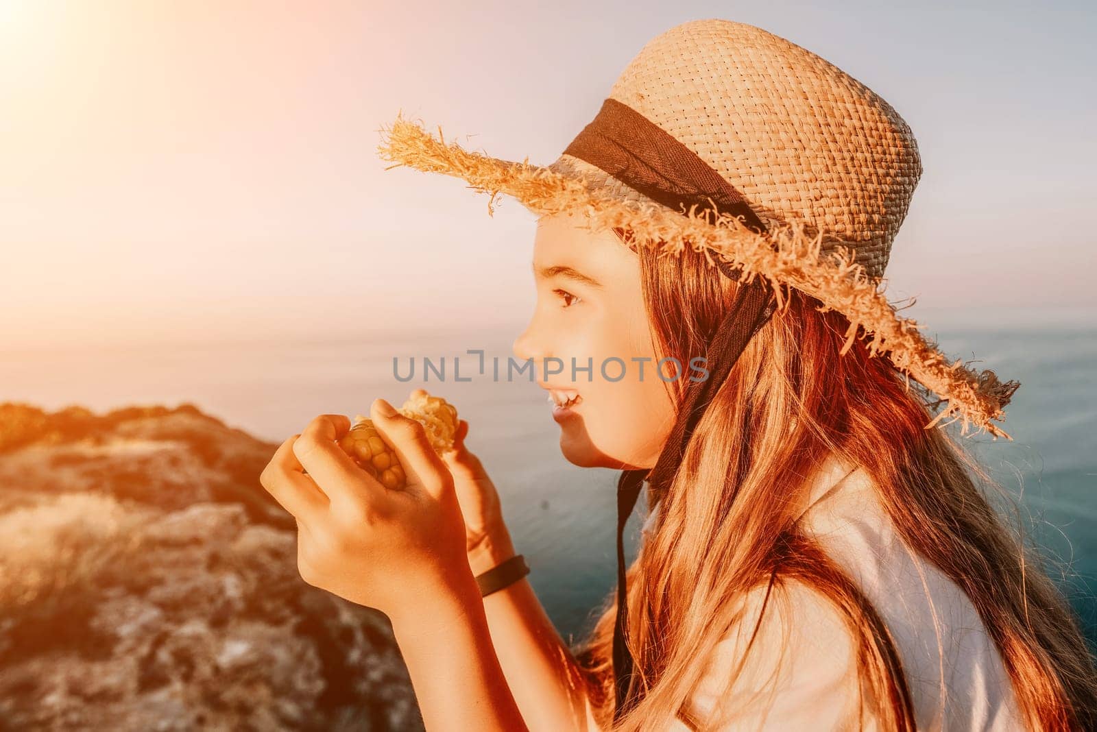 Portrait of young beautiful girl eating corn. Snacking on the sea