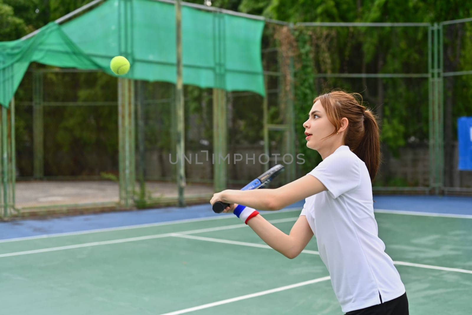 Athlete young woman hitting ball with racket during match. Fitness, sport, exercise concept.