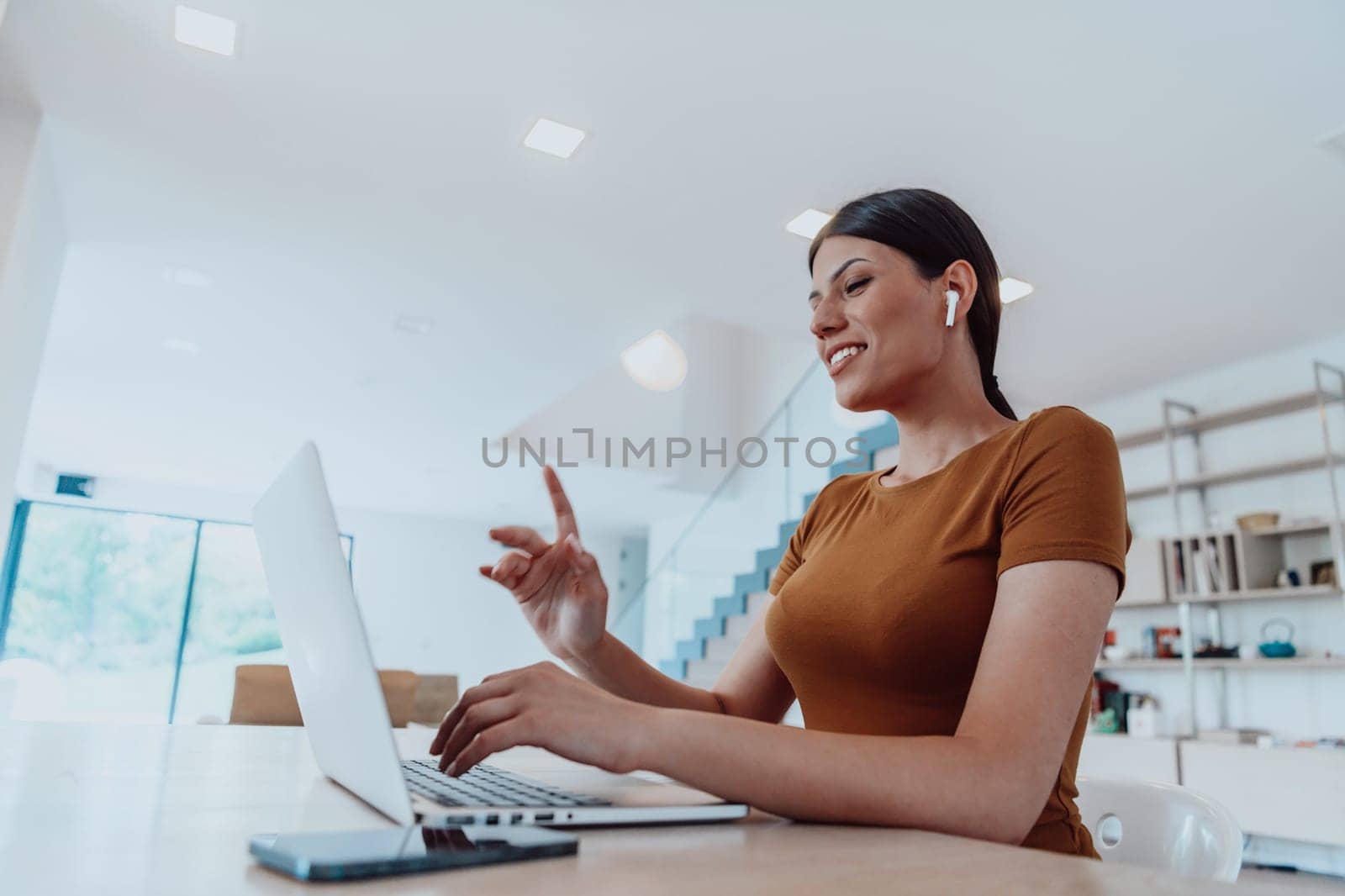 Woman sitting in living room using laptop looking at cam talk by video call with business friend relatives, head shot. Job interview answering questions