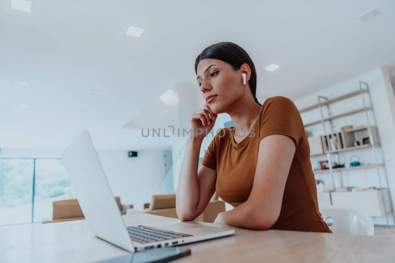 Woman sitting in living room using laptop looking at cam talk by video call with business friend relatives, head shot. Job interview answering questions