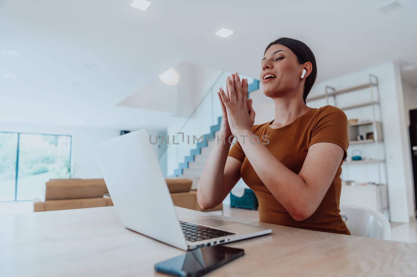 Woman sitting in living room using laptop looking at cam talk by video call with business friend relatives, head shot. Job interview answering questions