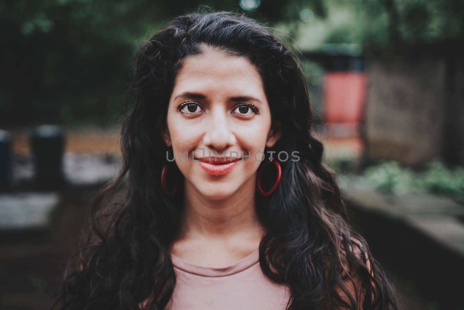 Portrait of attractive latin girl smiling outdoors. Close up of Latin American girl face looking and smiling at the camera. Portrait of young Nicaraguan woman smiling at camera by isaiphoto