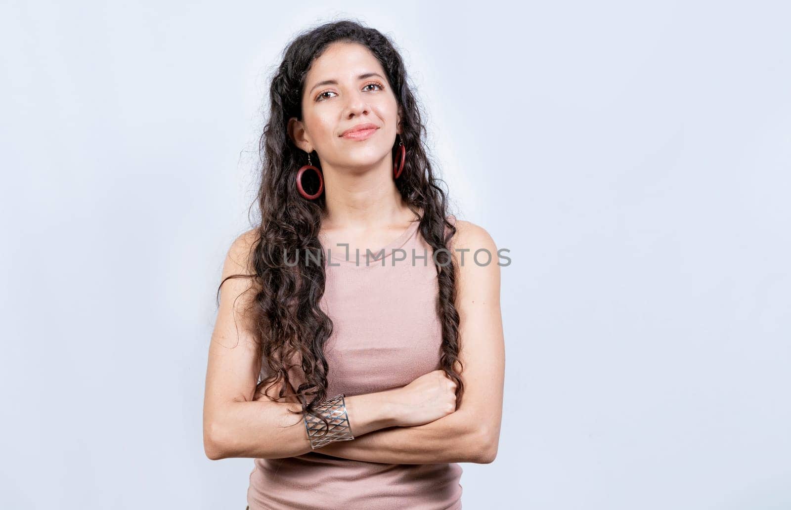Portrait friendly latin girl in white background. Beautiful latin woman with arms crossed isolated. Nicaraguan woman on isolated background by isaiphoto