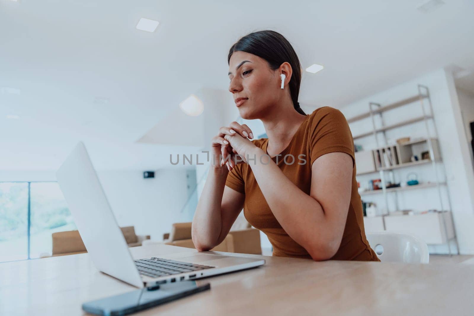 Woman sitting in living room using laptop looking at cam talk by video call with business friend relatives, head shot. Job interview answering questions