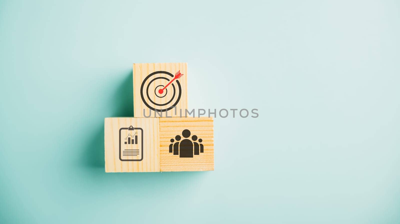 Wooden cube block step on a table with Action Plan, Goal, and Target icons. Success and business target concept. Project management and company strategy on a blue background.