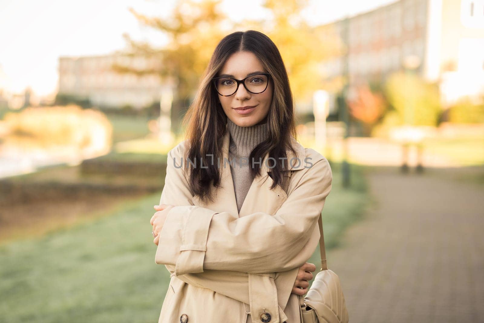 Beautiful LGTB woman 30s with glasses in the street confidently and profoundly looking towards the camera.