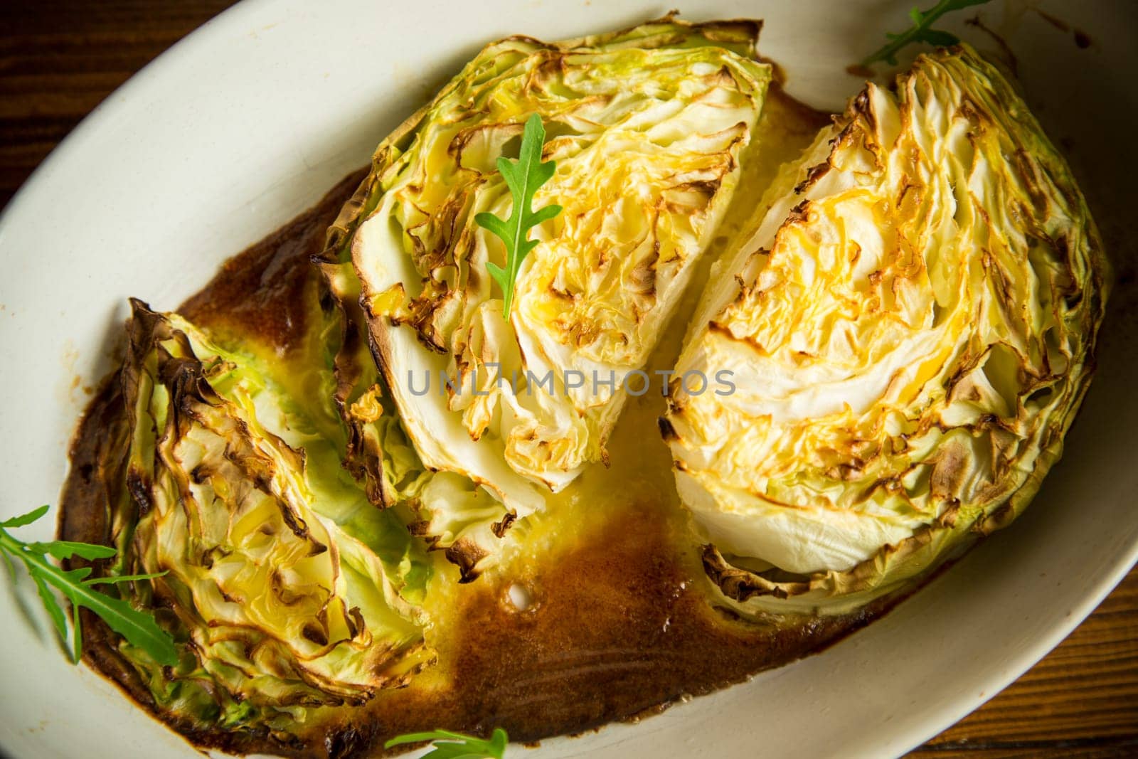 Young early cabbage baked in pieces in the oven, in a ceramic form.