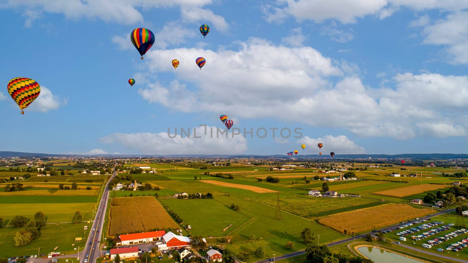 An Aerial View Of Many Hot Air Balloons Launching and Floating Away During a Balloon Festival on a Beautiful Summer Afternoon.