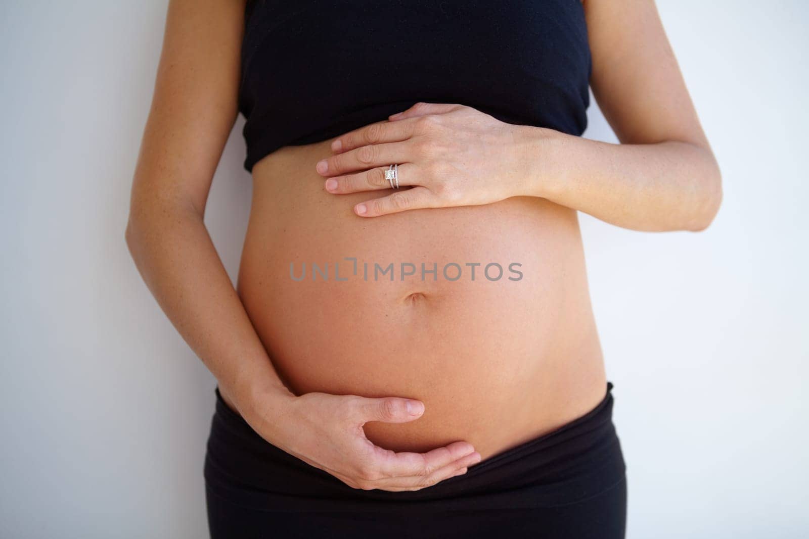 Pregnancy, woman and hands on stomach with love, care and support for healthy baby or maternity on white background. Pregnant, mother and hand on belly, tummy and wellness of body and motherhood.