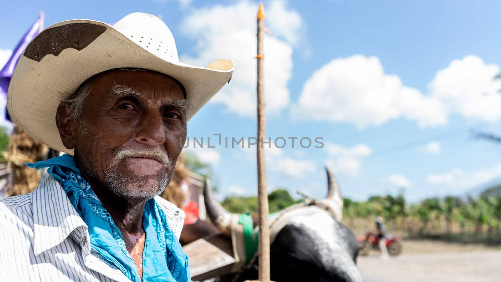 Closeup to the face of a Latino farmer with vitiligo who carries a rod to steer oxcarts by cfalvarez