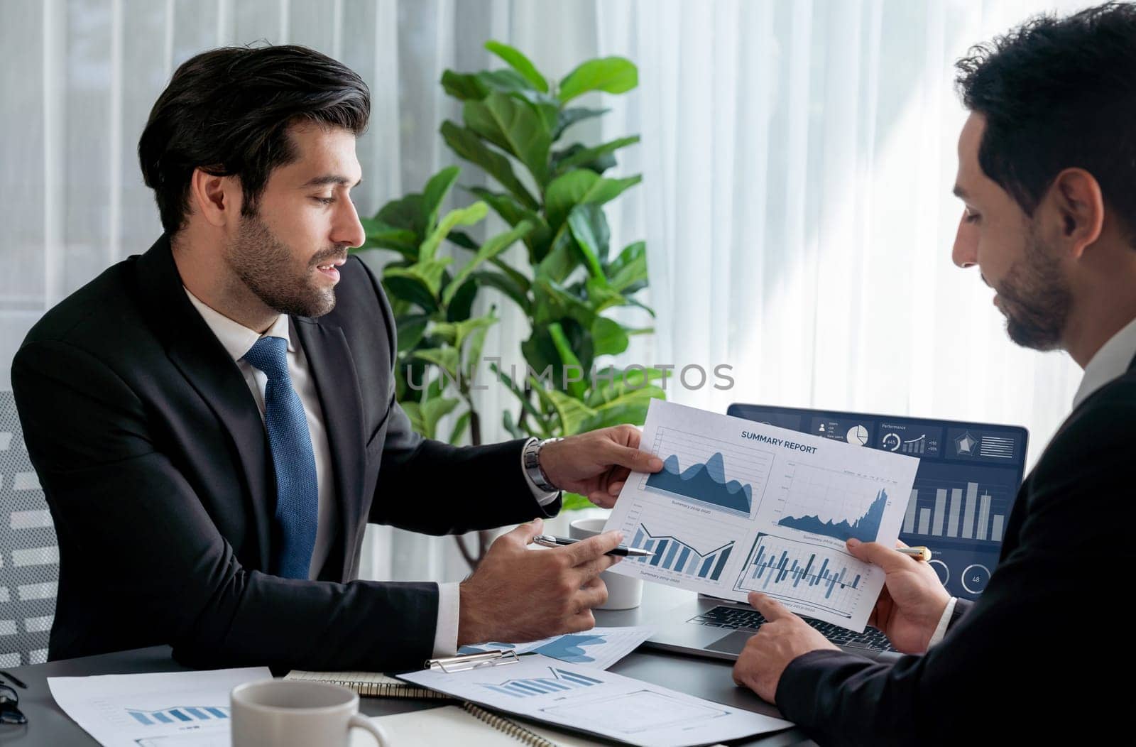 Busy analyst team discussing financial data on digital dashboard, analyzing chart and graph using data science software display on a laptop screen. Business intelligence and Fintech. Fervent