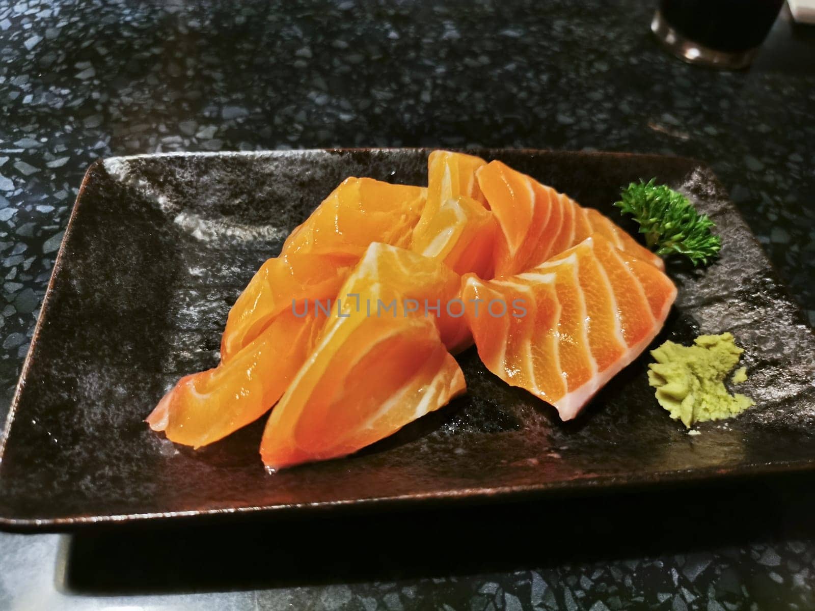 Fresh sashimi raw Atlantic Salmon pieces in Japanese restaurant served with wasabi paste