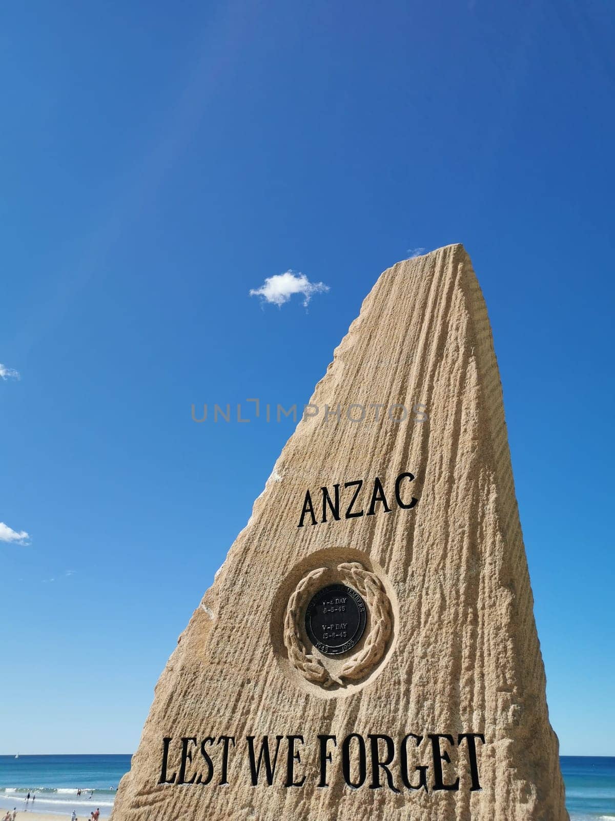 GOLD COAST, AUSTRALIA - AUGUST 16, 2020: Surfers Paradise Esplanade ANZAC War Memorial Stone with the shape looks like a fin and the text 'Lest We Forget'. This stone is located at Surfer Paradise beach. There is no body in the photo. by eyeofpaul