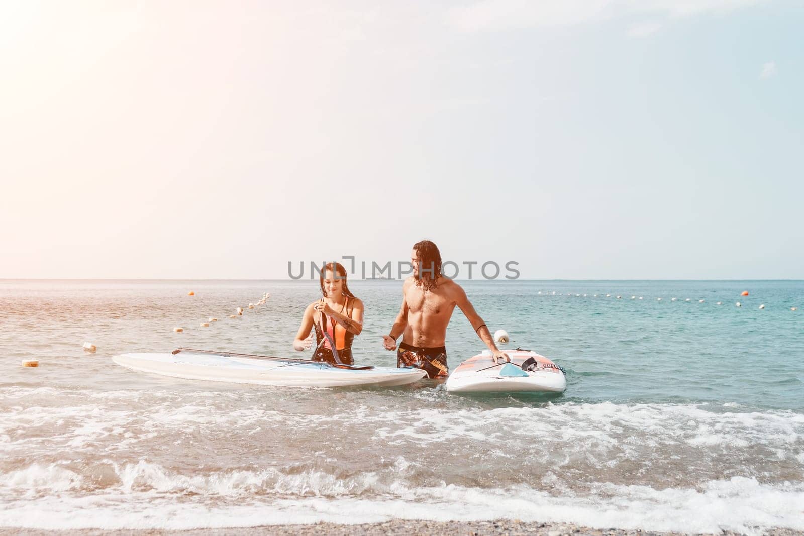 Woman man sea sup. Close up portrait of beautiful young caucasian woman with black hair and freckles looking at camera and smiling. Cute woman portrait in a pink bikini posing on sup board in the sea. by panophotograph