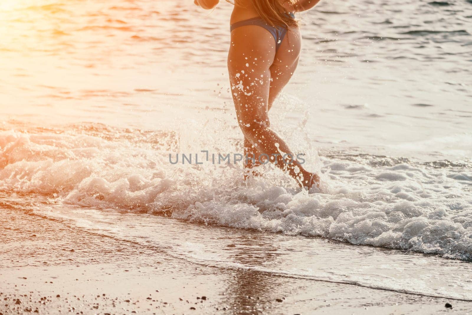 Running woman on a summer beach. A woman jogging on the beach at sunrise, with the soft light of the morning sun illuminating the sand and sea, evoking a sense of renewal, energy and health. by panophotograph