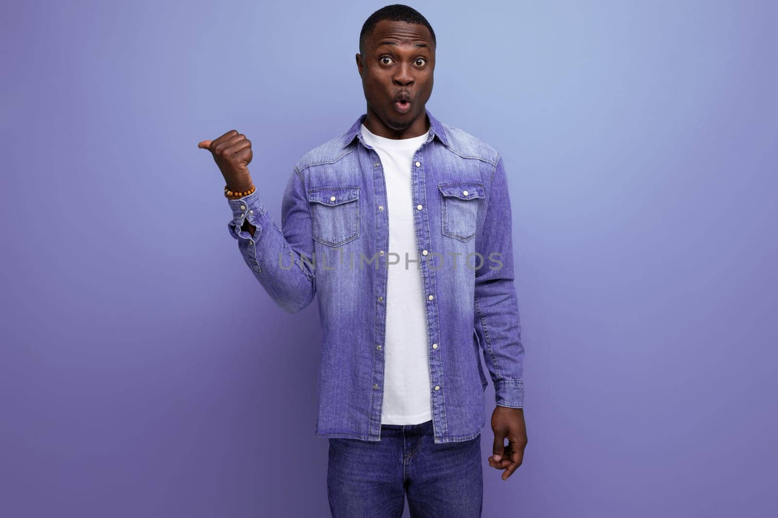 young handsome african guy in spring urban clothes pointing with his hands to the side on isolated background with copy space by TRMK