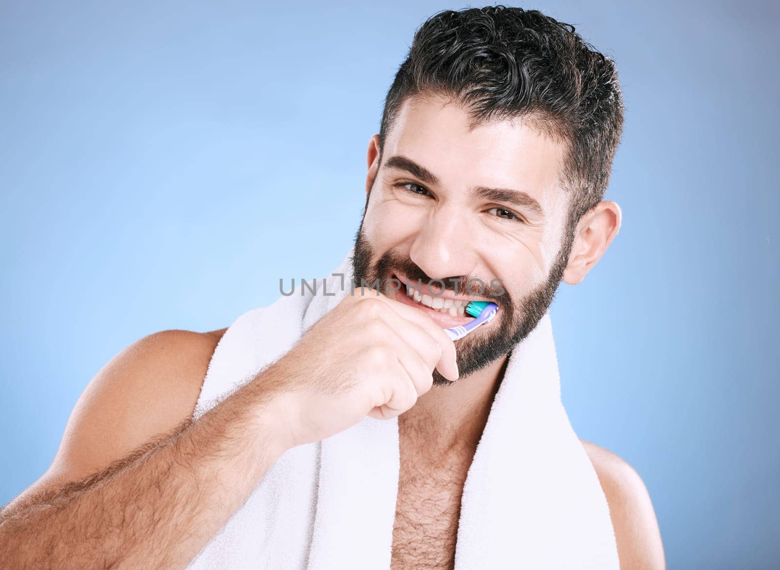 Toothbrush, portrait and man brushing teeth in studio for dental wellness, healthy smile and mouth. Happy male model, oral care and fresh breath for gums, dentistry and hygiene on blue background.
