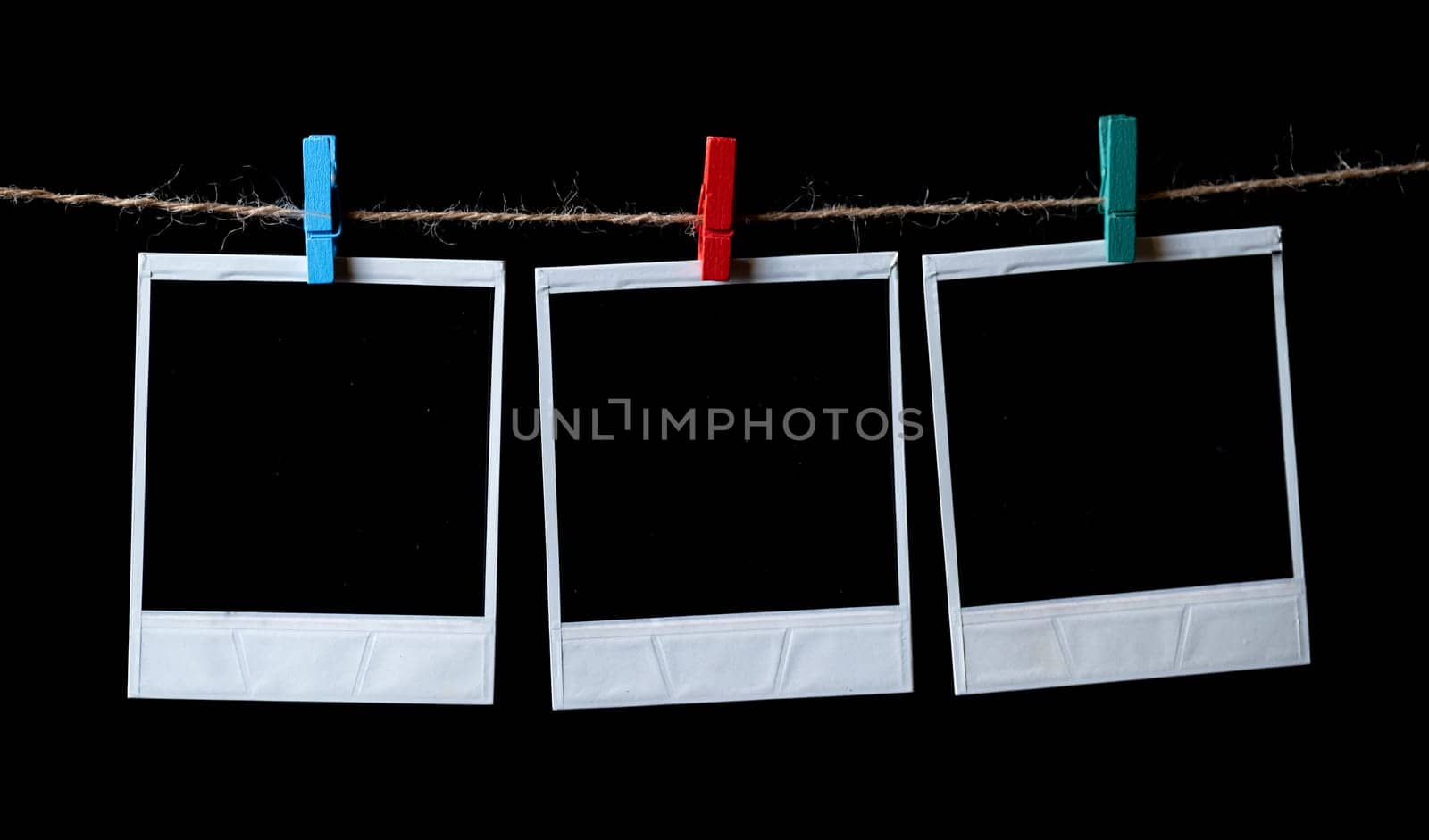 Blank square photo frames hanging on a clothesline. instant photo frames