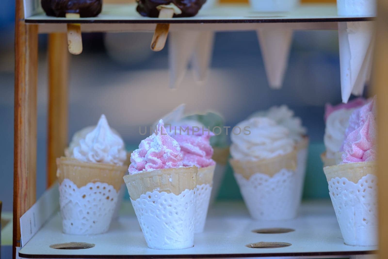 cream in a row. Variety of ice cream scoops in cones, vanilla and strawberry. classic Italian gourmet gelato ice cream by igor010