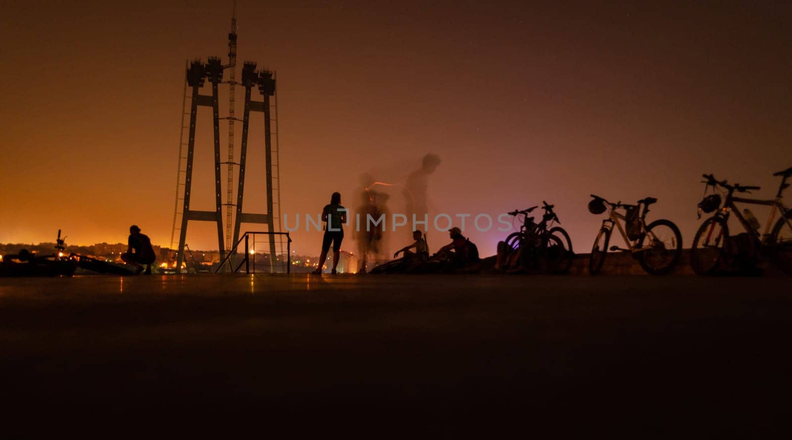 Cycling outdoor adventure. bikes with people night landscape. Outdoor sport activity. silhouette of group people with bicycles on industrial background