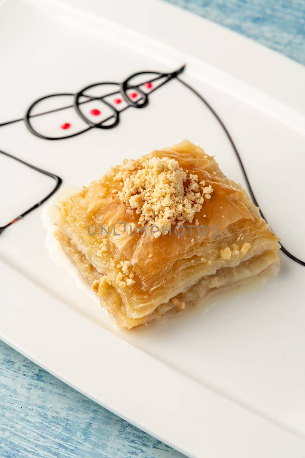 Turkish baklava with hazelnuts on a white porcelain plate by Sonat