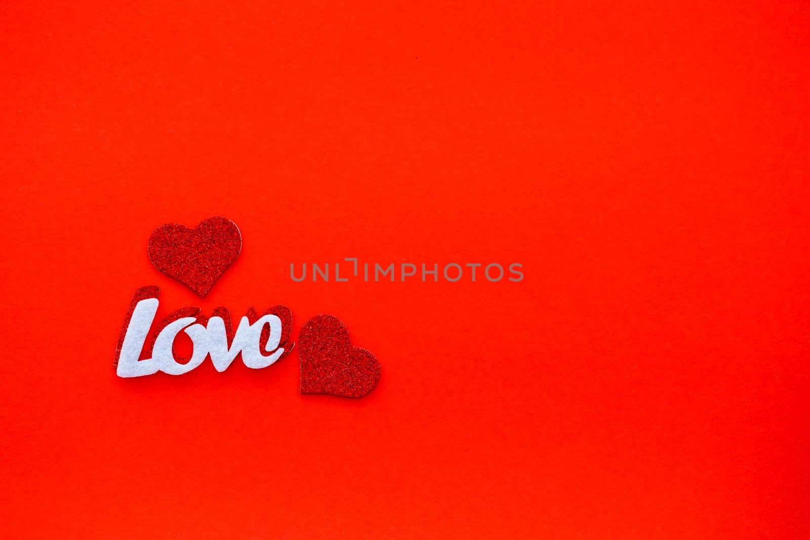 Valentine's day red background with wooden hearts and the word love. Place for inscriptions, advertising