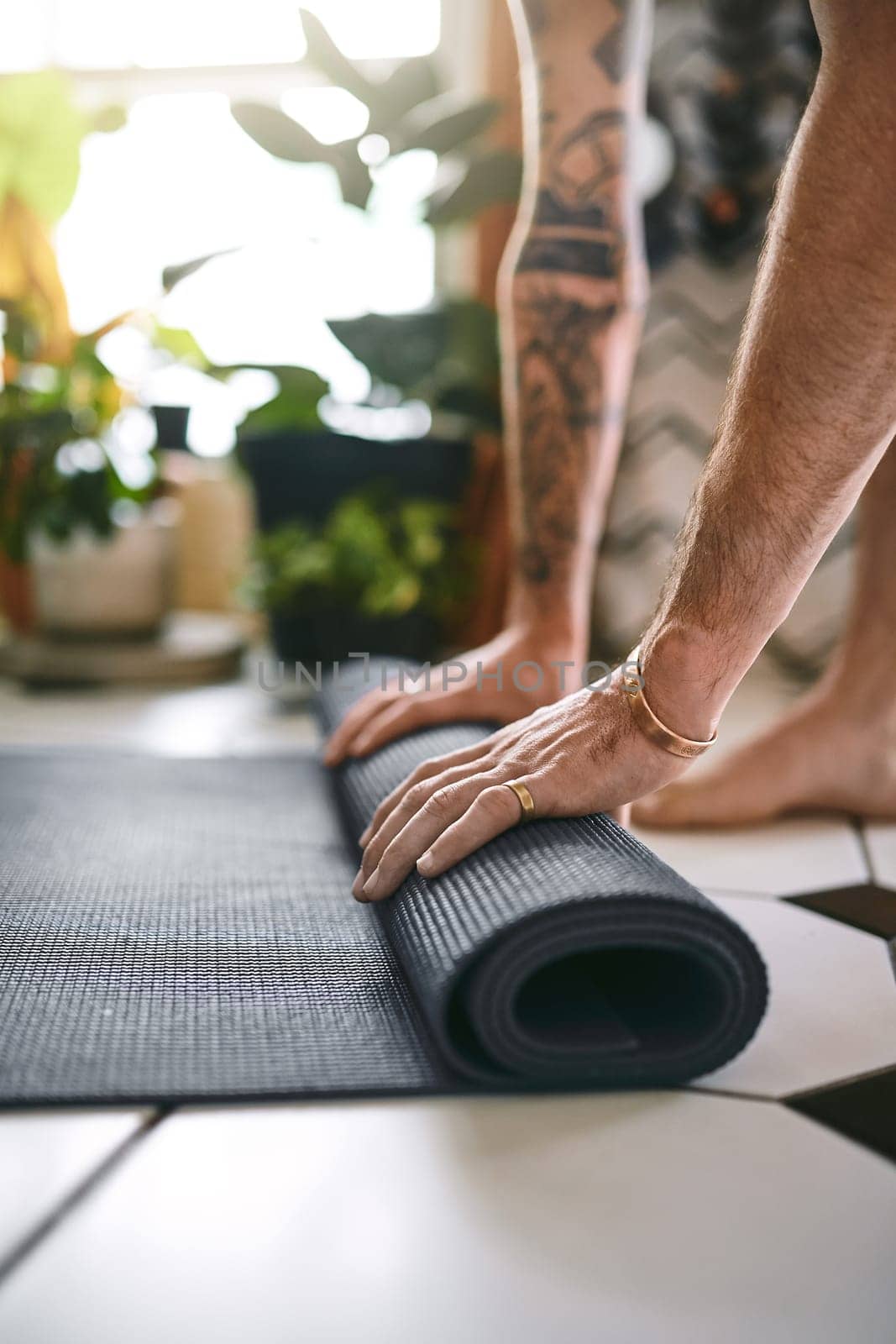 Yoga keeps you grounded. an unrecognisable man rolling up his yoga mat at home