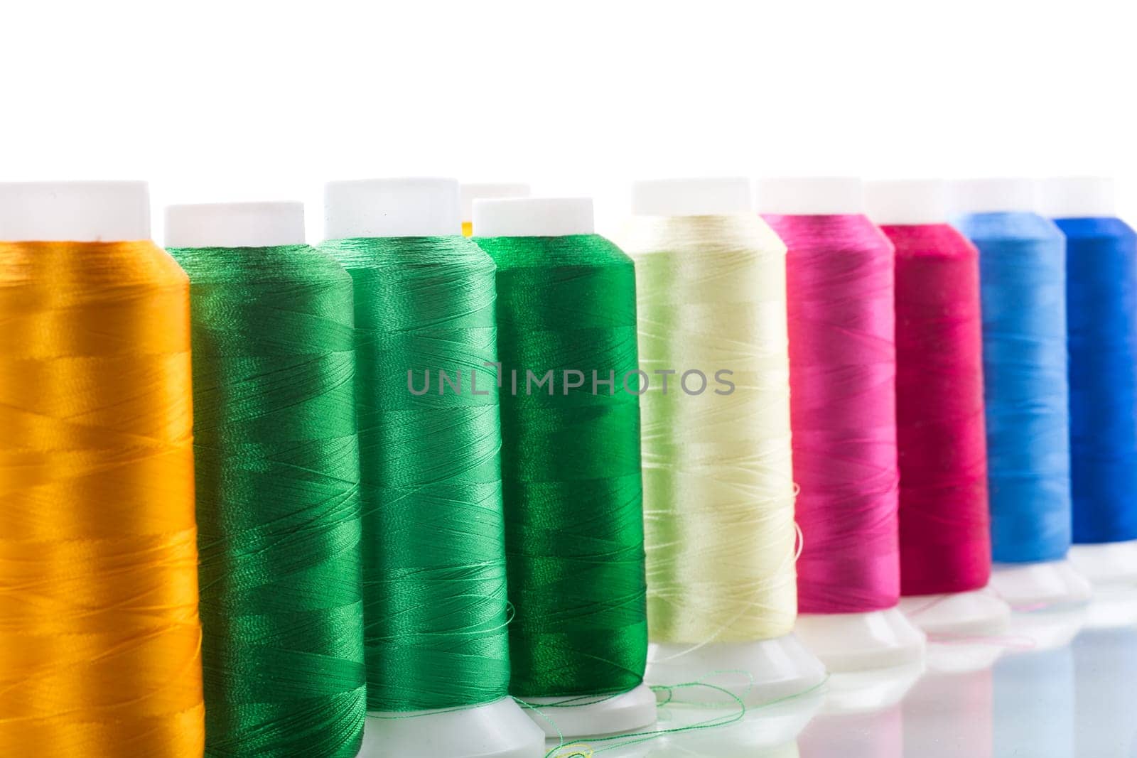 set of different color sewing threads, isolated on white background.