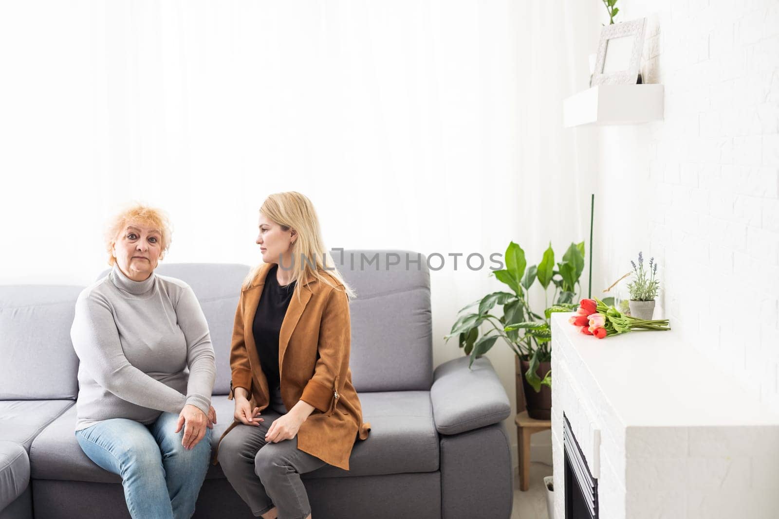 Young woman and mother spending time together at home. by Andelov13