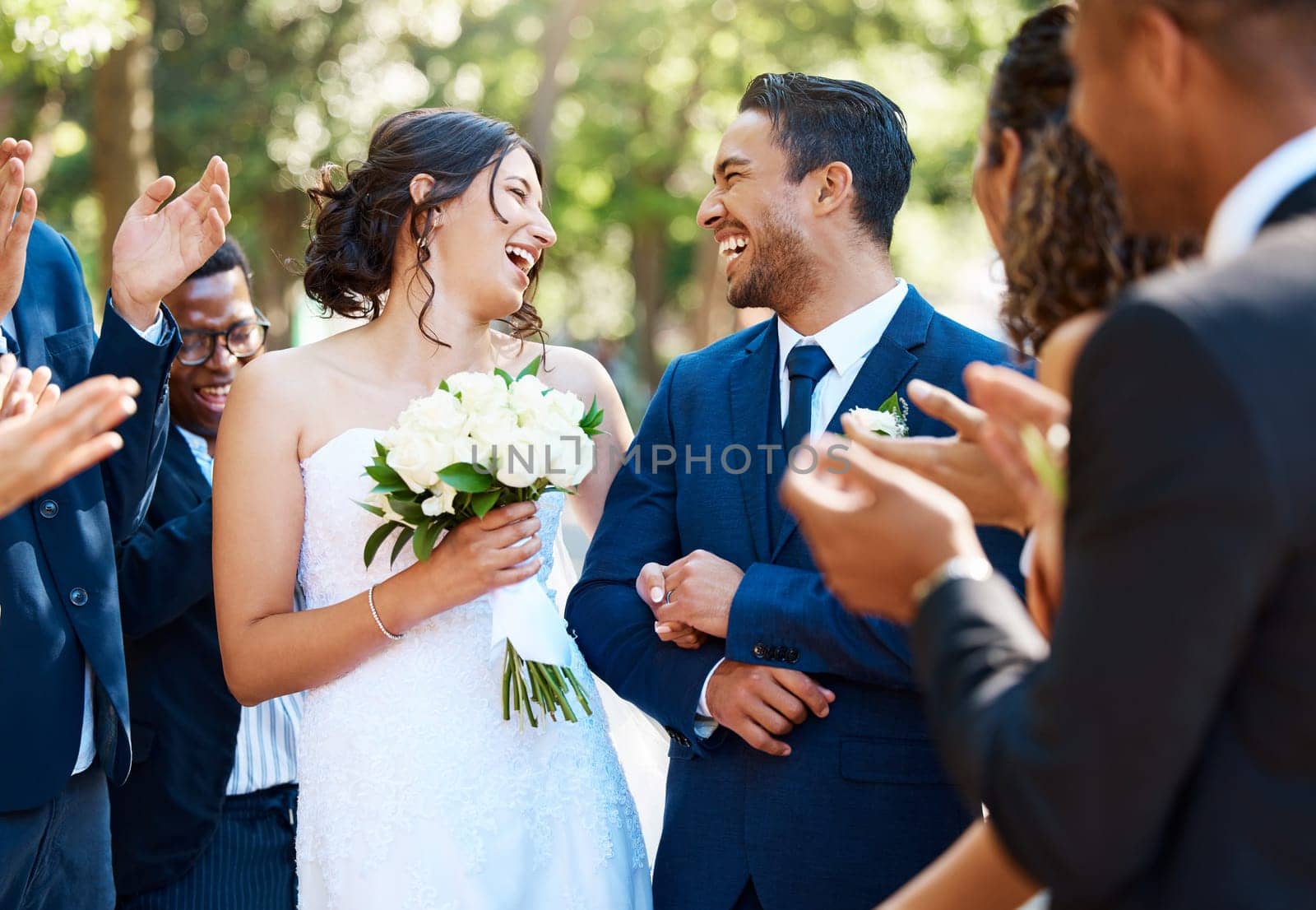 Wedding ceremony, couple and people clapping hands in celebration of love, romance and union. Happy, smile and bride with bouquet and groom walking by guests cheering for marriage at an outdoor event by YuriArcurs