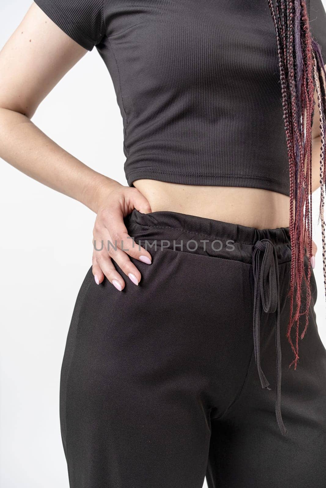 Fashionable young beautiful woman with dreadlocks posing on white background by Desperada