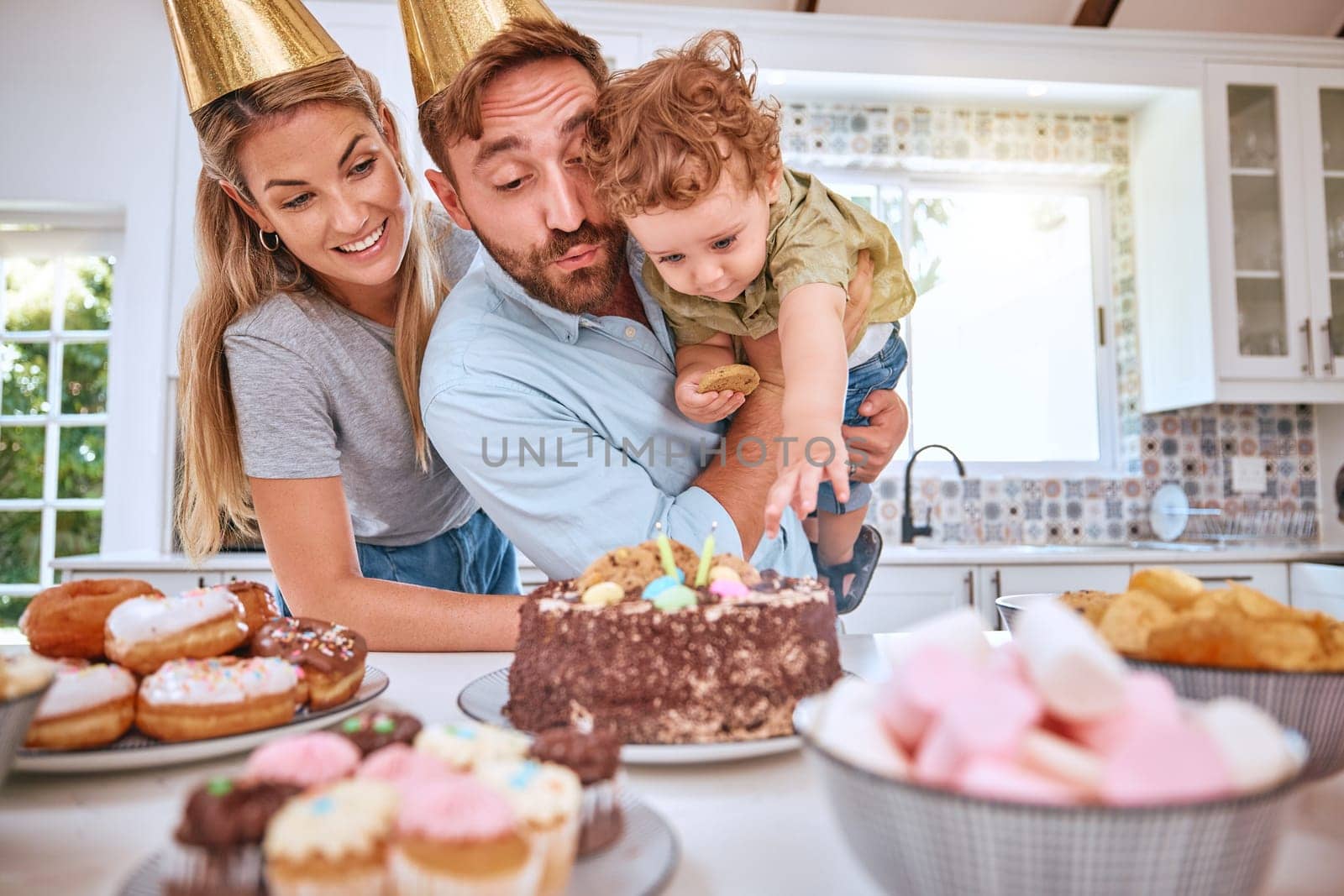 Family, birthday and celebrating child with party and cake at home while having fun. Mother, father and little boy celebration with a birthday party, dessert and sweet candy for love and care.