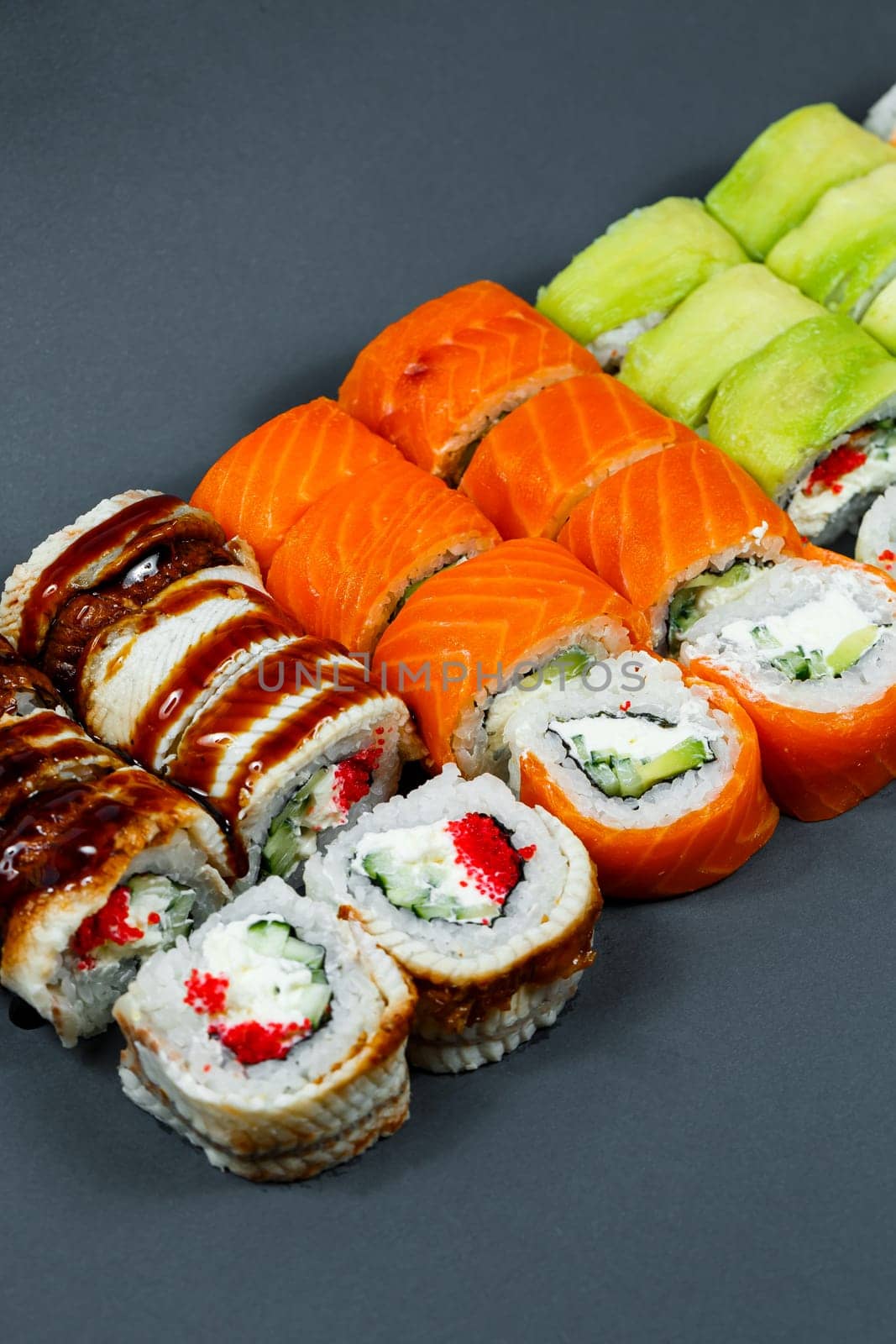 Sushi assorted. Sushi roll with avocado, cucumber. Sushi roll with salmon and caviar. Sushi roll with tuna and caviar. On a light background. Japanese food. View from above