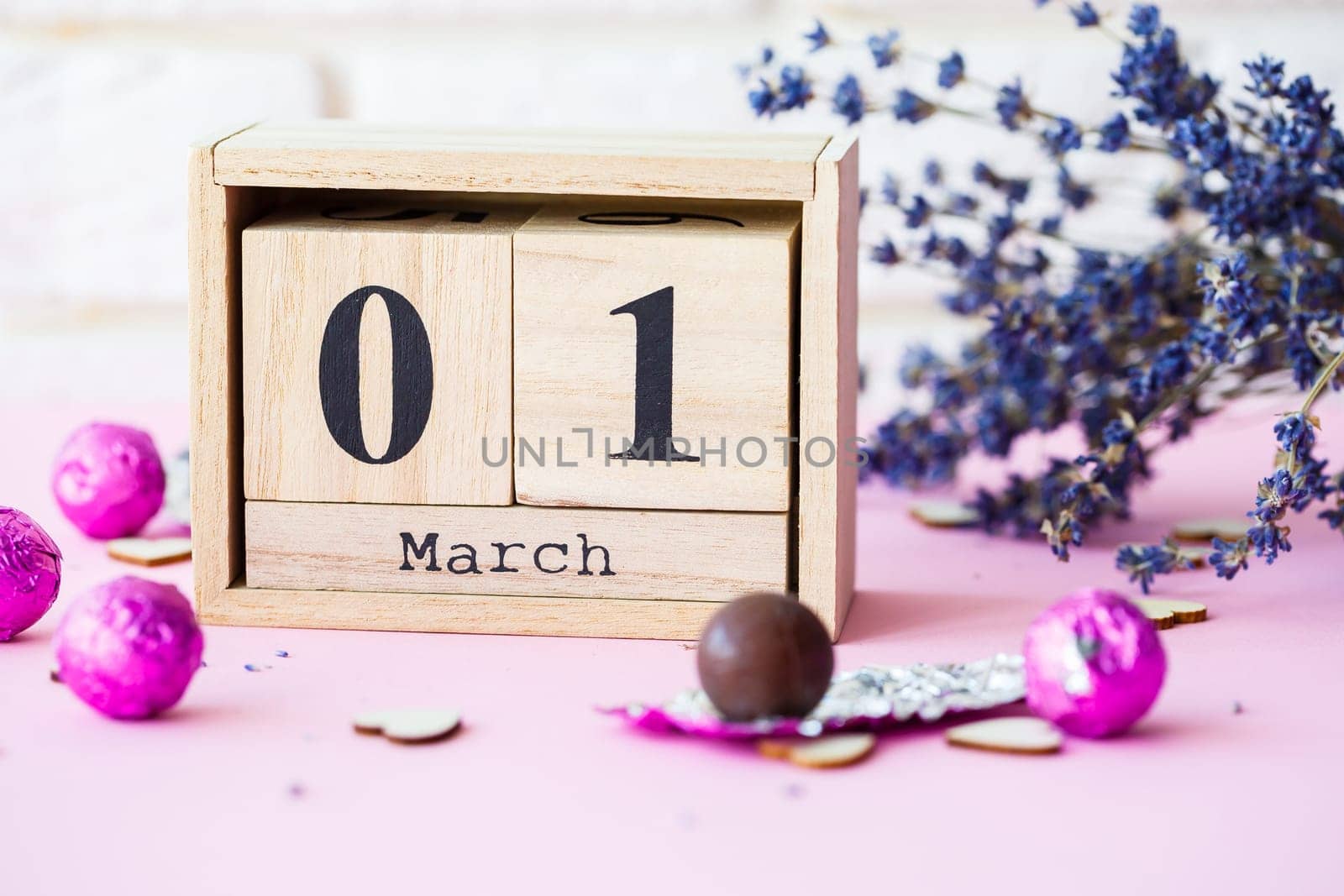 Wooden calendar with the date of March 1 on a pink background, a place for an inscription, The first day of spring, a dry branch of lavender