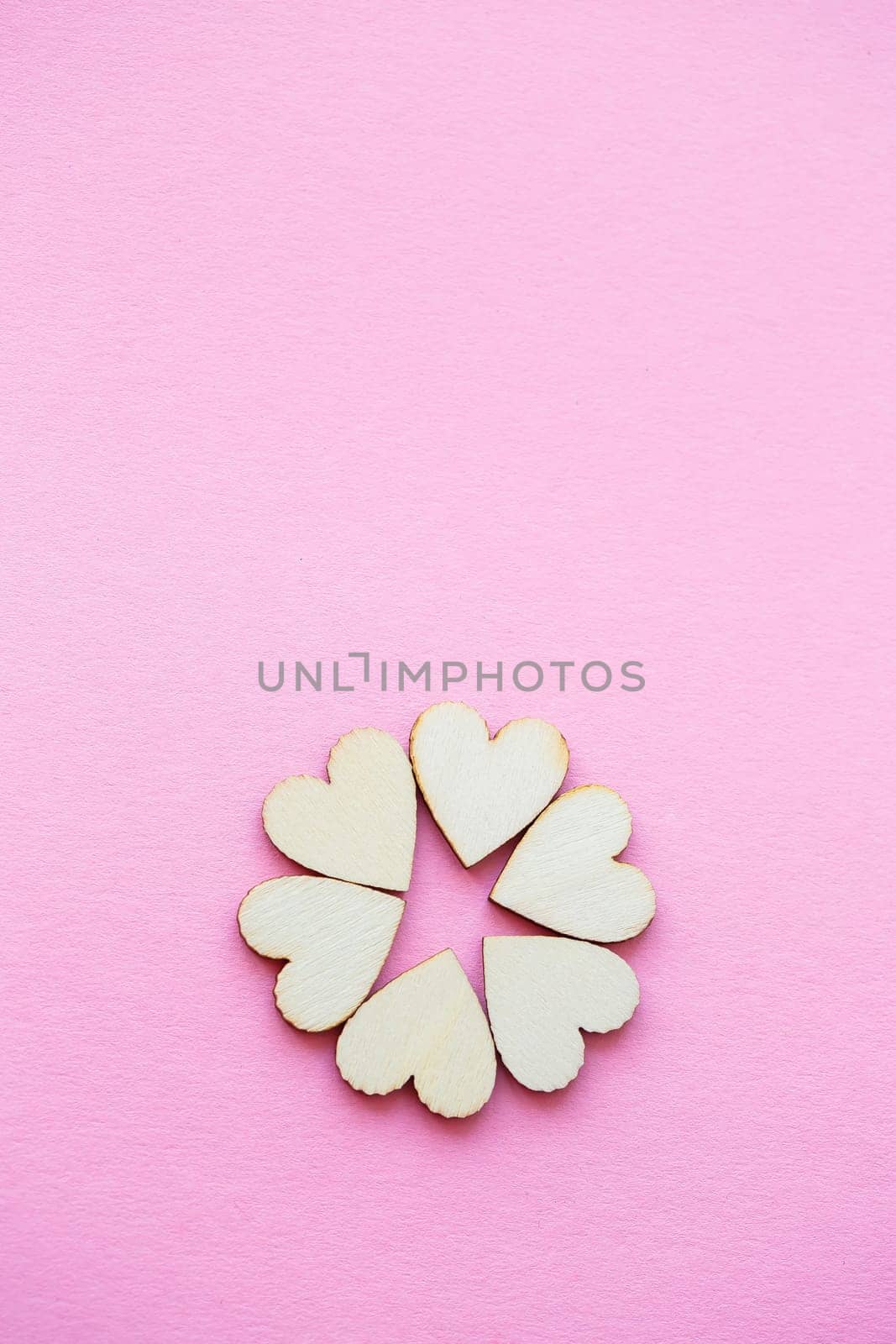 Valentine's day background. row of wooden hearts on a pink background. Valentine's day concept. Top view, place for an inscription, advertising