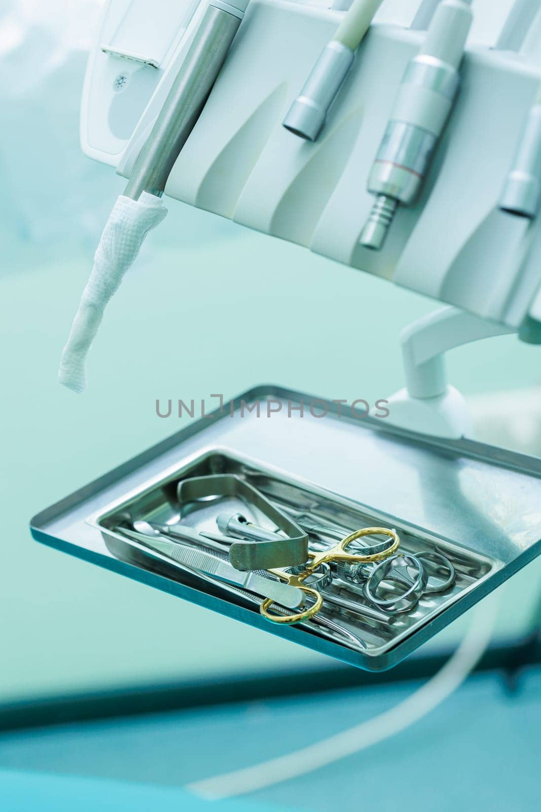 Tray with metal dental tools. Tools of the dentist. Interior of a patient reception room with dental equipment in a dental clinic.