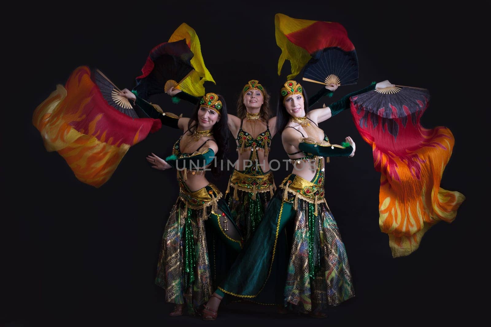 Image of young graceful oriental dance performers posing in studio