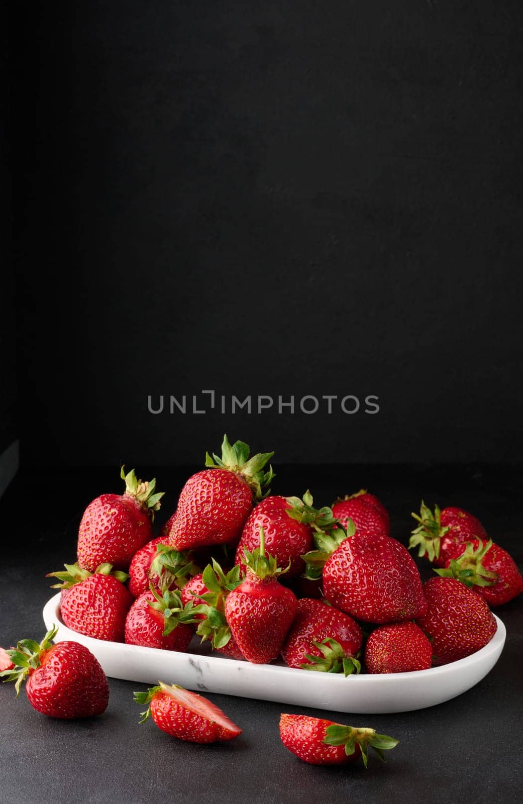 Ripe red strawberries on a black table