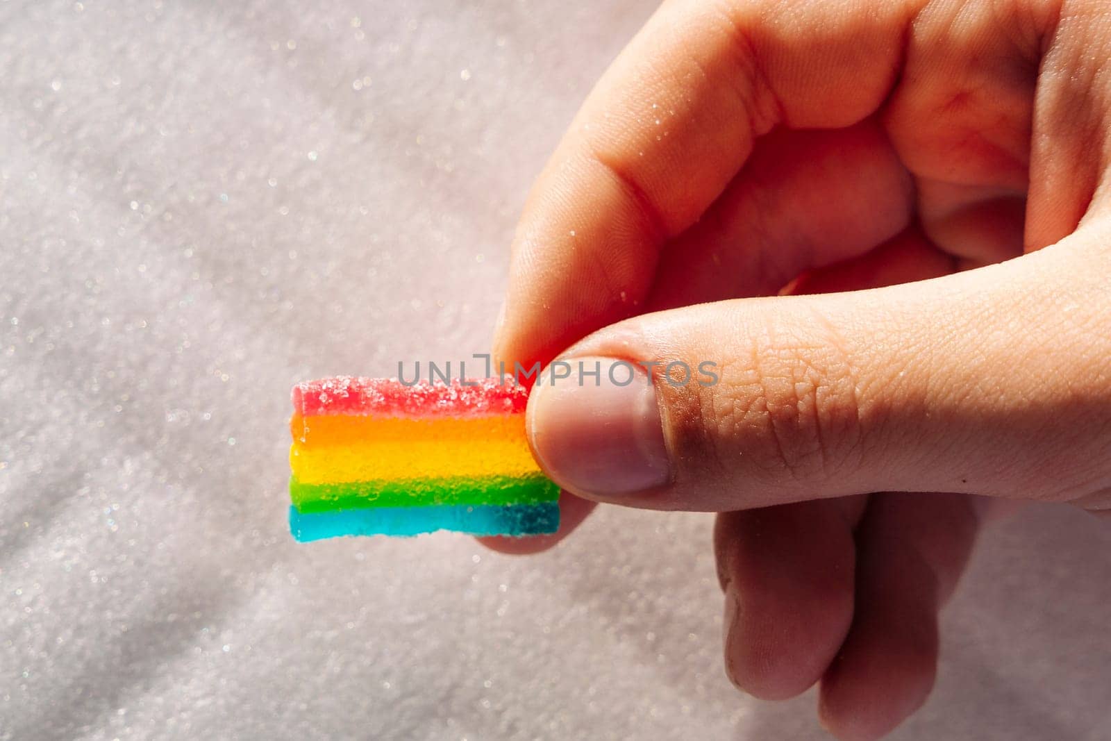 Rainbow marmalades in the child's hand. Goodies and sweets . Children's joys. Sweet and sour chewing plates with sugar. Bright colored candies, marmalade or sweets. unhealthy food