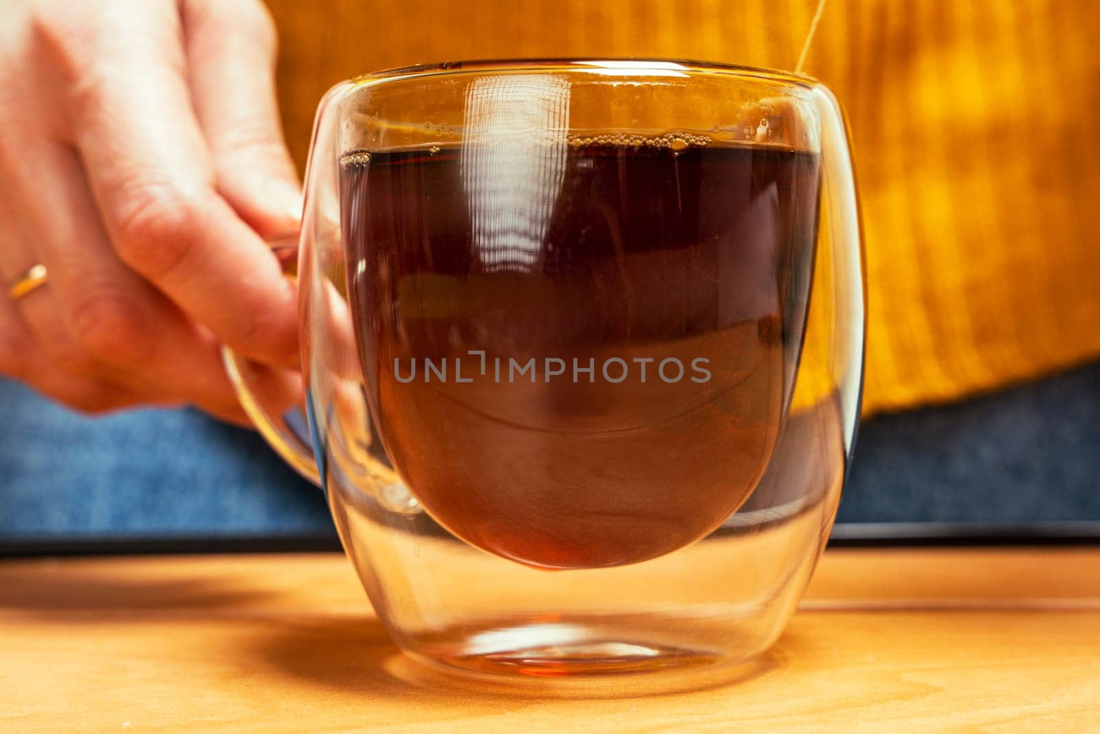 tea glass mug with tea bag for brewing close-up. brewing tea in a transparent mug. Warm soft tones. A sincere tea party in a warm atmosphere. Herbal teas